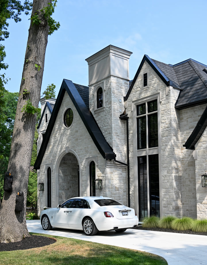 Ravine Drive custom home with stone walls, steep gables and tall windows